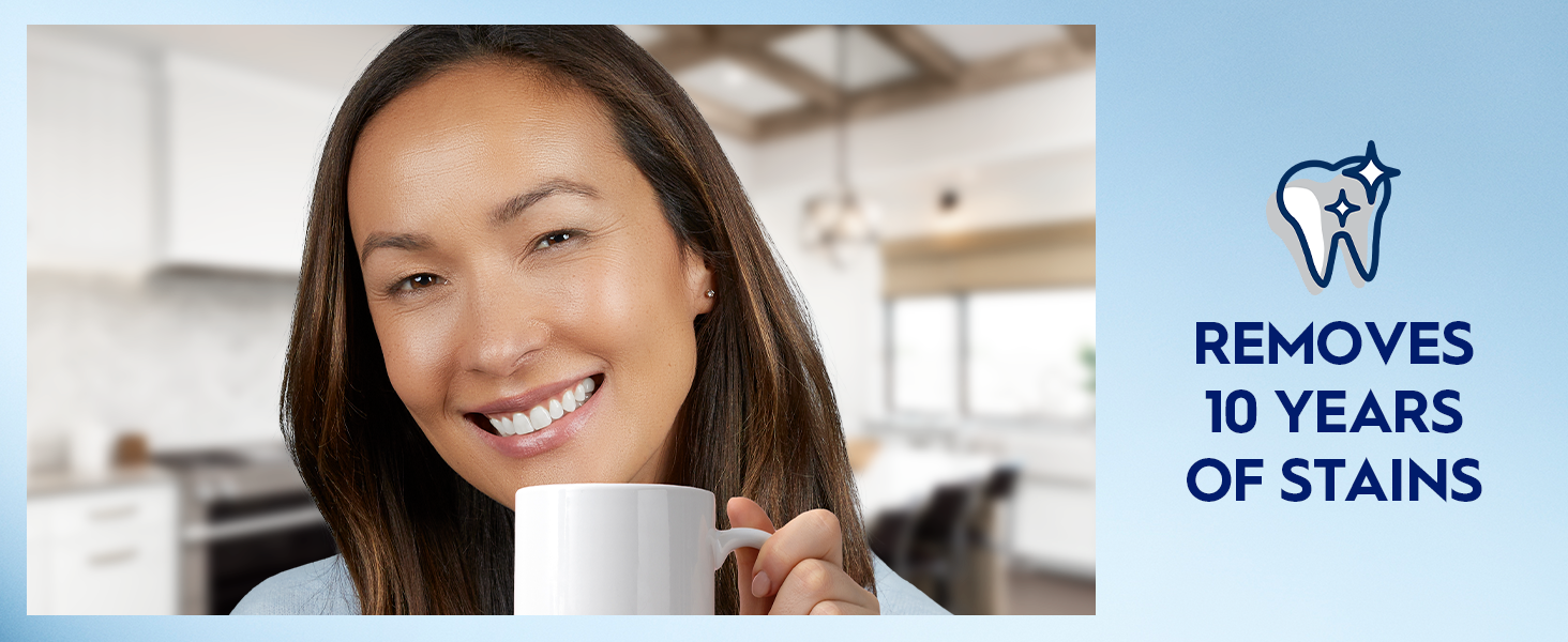 A woman smiles bright while holding a white coffee mug. Claim reads: Removes 10 years of stains